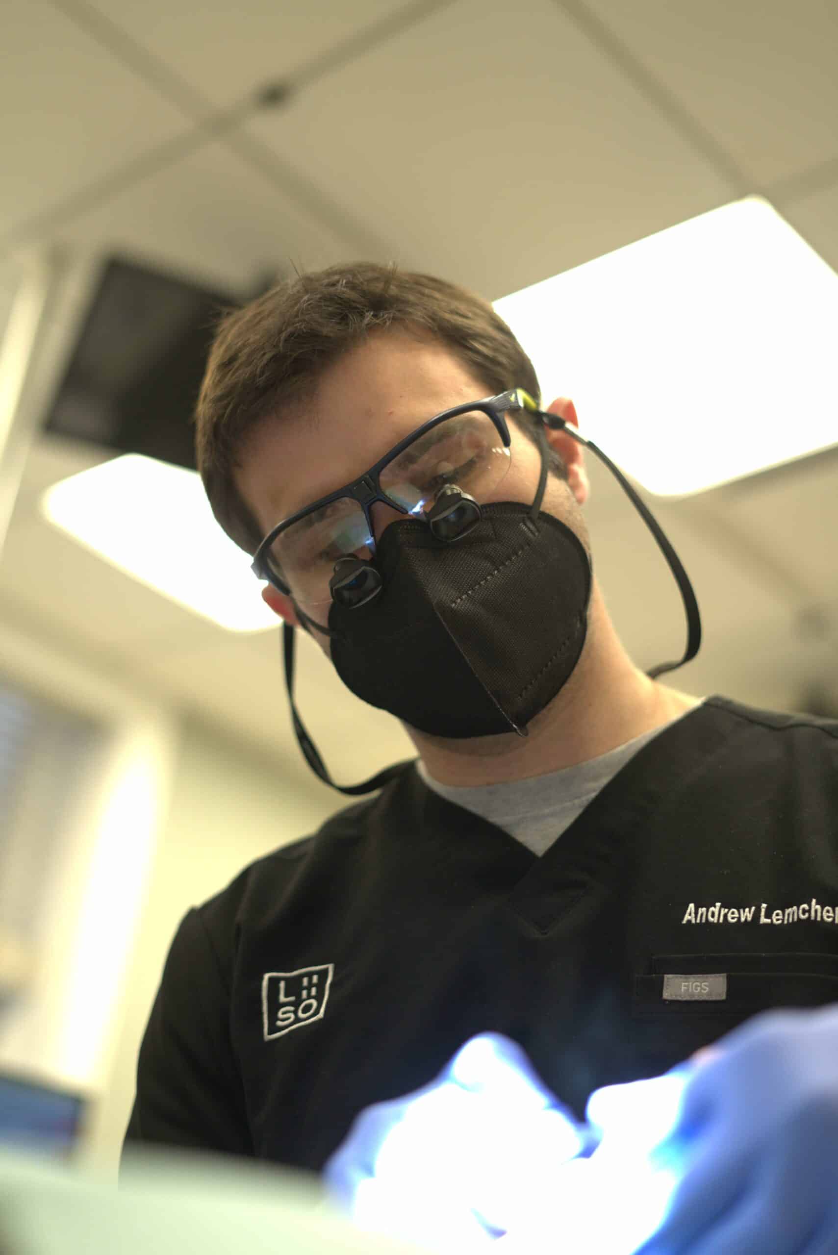 Orthodontist wearing magnifying loupes while providing crowded teeth correction for a patient in NYC