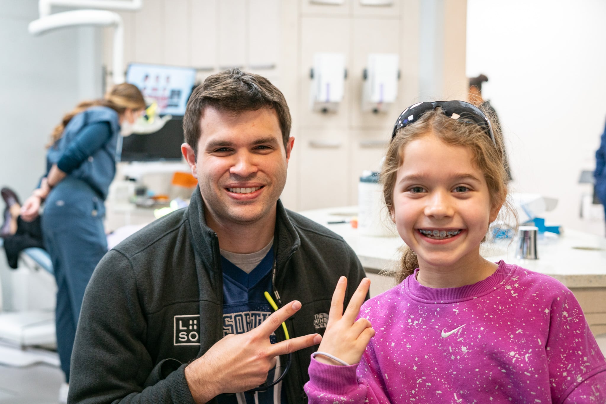 Orthodontist and young patient making peace signs at a top orthodontist NYC office